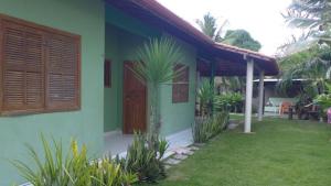una casa verde con una puerta y algunas plantas en Refúgio Beira Mar, en Santa Cruz Cabrália