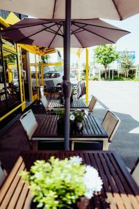 un groupe de tables avec parasols sur un patio dans l'établissement Design Hotel Euskirchen, à Euskirchen