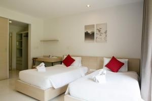 2 camas con almohadas rojas en una habitación en The Silver Palm Wellness Resort, en Bangkok