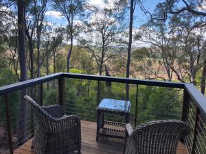 a deck with two chairs and a table on it at Redrock Retreat in Kingaroy
