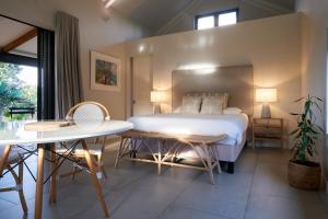 a bedroom with a bed and a table and chairs at Peaceful Tree Cottage in Tamarin