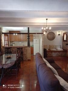 uma sala de estar com um sofá, uma mesa e uma cozinha em Casa Rural Juan, el Zapa em Letur