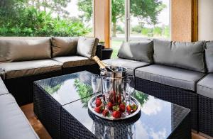 a coffee table with a pitcher and strawberries on it at 7 Room PgaVillageResort by AmericanVacationliving in Port Saint Lucie