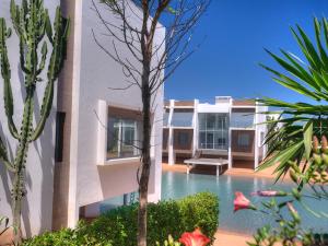 a house with a swimming pool next to a building at Eden Island Villa - Bouznika in Bouznika