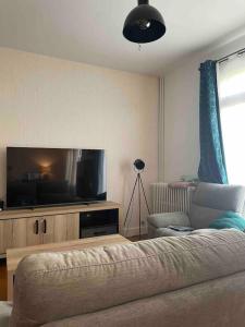 a living room with a flat screen tv and a couch at Manornella, beaux volumes, grand garage idéal Mas du Clos in Aubusson