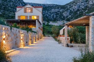 a house with a stone wall and a pathway at Villa Vito in Hvar