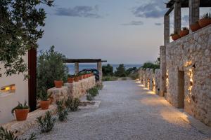 a pathway with a stone wall with lights on it at Villa Vito in Hvar