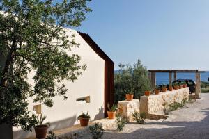 a white building with a row of potted plants at Villa Vito in Hvar