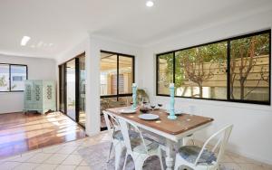 uma sala de jantar com mesa e cadeiras em Large, Light, dog friendly home 600m to Burleigh beach em Gold Coast