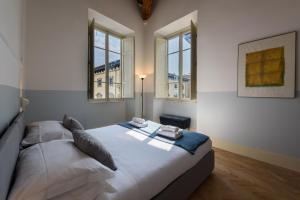 1 dormitorio con 1 cama en una habitación con ventanas en Casa Barontini en Florence