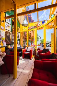 a restaurant with red couches and tables and windows at Design Hotel Euskirchen in Euskirchen