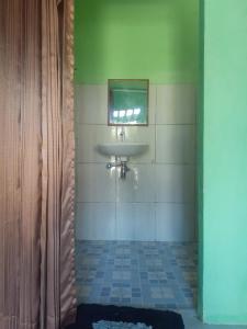 ein Bad mit einem Waschbecken und einem Spiegel in der Unterkunft Nadil Homestay in Kuta Lombok