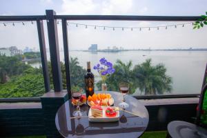 een tafel met een bord eten en een glas wijn bij Lake View Hotel in Hanoi