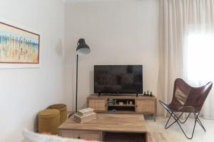een woonkamer met een flatscreen-tv en een stoel bij Katofli Slow Living in Pithárion