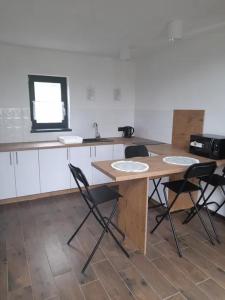 kuchnia ze stołem, krzesłami i zlewem w obiekcie Domki Blisko Nieba III w Wiśle