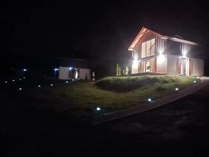 ein Haus mit seitlicher Beleuchtung in der Nacht in der Unterkunft Domki Blisko Nieba III in Wisła