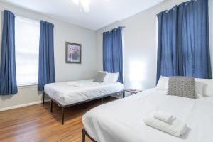 Sunny Sweetheart-Front Apartment near Riverwalk في كولومبوس: سريرين في غرفة مع ستائر زرقاء