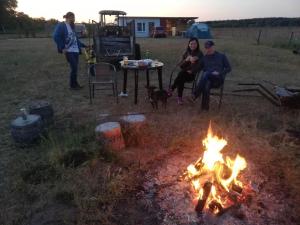 Eine Gruppe von Menschen, die um ein Feuer herum sitzen in der Unterkunft Peace & Quiet in Sławoborze