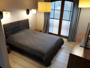 1 dormitorio con 1 cama y 2 ventanas en Dom przy stoku, en Bałtów