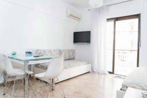 sala de estar blanca con mesa y sofá en Zennova #7 Nea Plagia Beach, en Nea Plagia