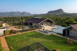 an aerial view of a house with a yard at StayVista's The Barn - Mountain-View Luxury Mansion with Heated Infinity Pool, Deck, Jacuzzi, Lawn featuring a Gazebo and Firepit in Lonavala