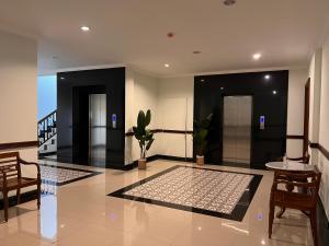 a lobby with two elevators and a table and chairs at LE SEMAR HOTEL KARAWACI in Dahung