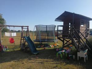 un parque infantil con tobogán y columpio en Peace & Quiet en Sławoborze