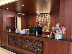 a man standing at a reception desk with a computer at LE SEMAR HOTEL KARAWACI in Dahung