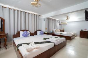 a hotel room with two beds with blue and white pillows at Siem Reap Riverside Hotel in Siem Reap