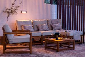 uma sala de estar com um sofá e duas cadeiras e uma mesa em Koroni Xenios Zeus, Seaview Summer Retreats em Koroni