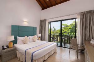 a bedroom with a large bed and a balcony at South Lake Resort Koggala in Koggala