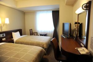 a hotel room with two beds and a desk with a telephone at Hotel Route-Inn Ena in Ena