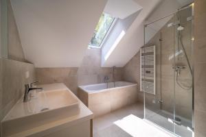 La salle de bains est pourvue d'un lavabo, d'une douche et d'une baignoire. dans l'établissement Holiday House U Hájenky 12P Lipno Home, à Lipno nad Vltavou