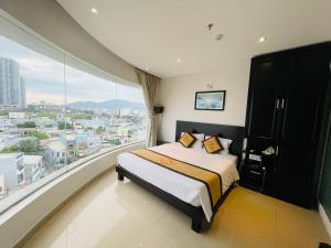 een slaapkamer met een bed en een groot raam bij D&C Hotel in Da Nang