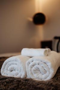 two rolled towels sitting on top of a bed at Jaspers Cabins in Pemberton