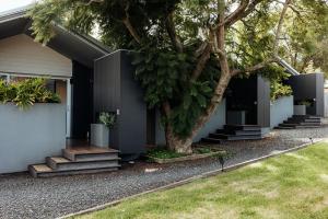 een huis met een boom ervoor bij Jaspers Cabins in Pemberton