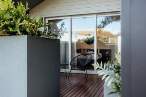 a porch with a chair and some plants on it at Jaspers Cabins in Pemberton