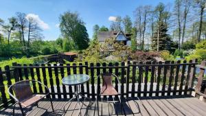 a table and chairs on a wooden deck with a fence at Domek Natalia in Giżycko