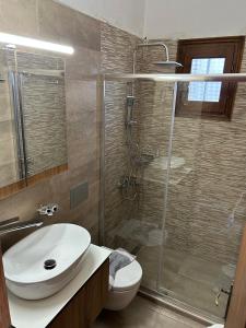 y baño con aseo, lavabo y ducha. en Villa Sunray, en Agios Ioannis