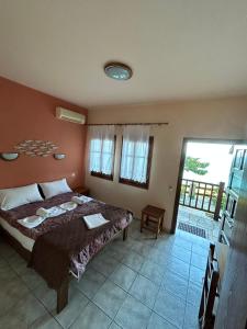 a bedroom with a bed and a large window at Villa Sunray in Agios Ioannis Pelio