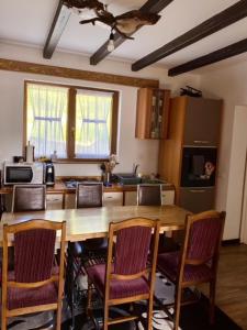 a kitchen with a wooden table with chairs and a kitchen with a counter at Cabana Bogdi in Borşa