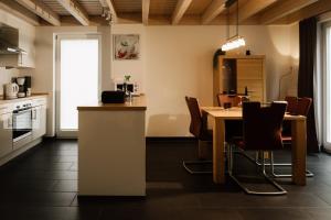 een keuken en eetkamer met een tafel en stoelen bij Ferienhaus Nordhorn - Auf Wolke 7 und Seeparadies in Nordhorn