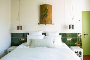 a bedroom with a white bed and a green wall at Les Chambres de la Relève in Marseille
