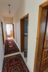 an empty hallway with a door and a rug at Adventurous Local Hostel in Fethiye
