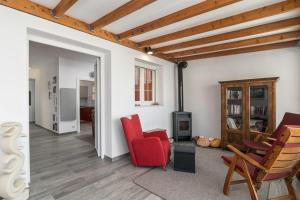 a living room with a red chair and a table at Casa Mia Milos in Paleochori