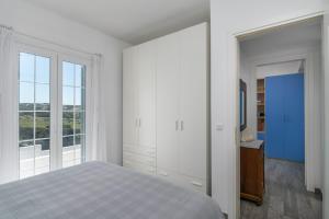 - une chambre blanche avec un lit et une fenêtre dans l'établissement Casa Mia Milos, 