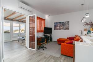 - un salon avec un canapé orange et un bureau dans l'établissement Casa Mia Milos, 