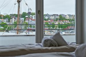 ein Bett mit Hafenblick aus einem Fenster in der Unterkunft Schiffbrücke in Flensburg