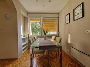 a dining room with a table and chairs and a window at Apartment Sole Dorato in Rijeka