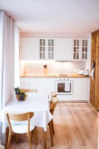 a kitchen with white cabinets and a table and chairs at MiMaMo in Põlva